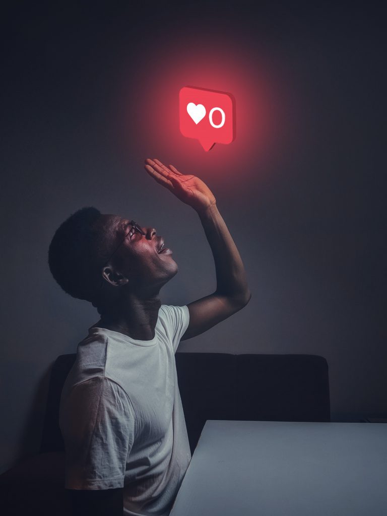 A man reaching up to a floating Instagram like button. 