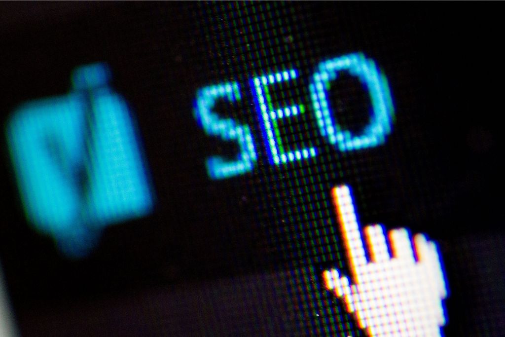An image of blue text that says "SEO" with a finger cursor hovering just below it.