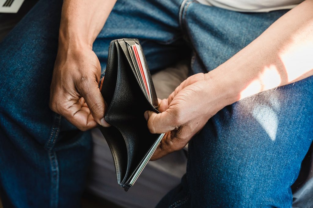 A man looking inside an empty wallet